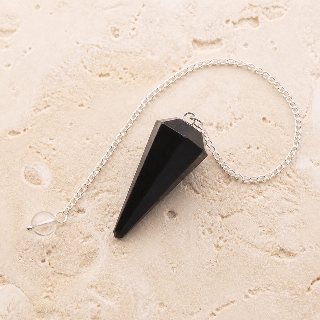 Pendule hexagonal en tourmaline noire, vue complète sur une surface minérale claire