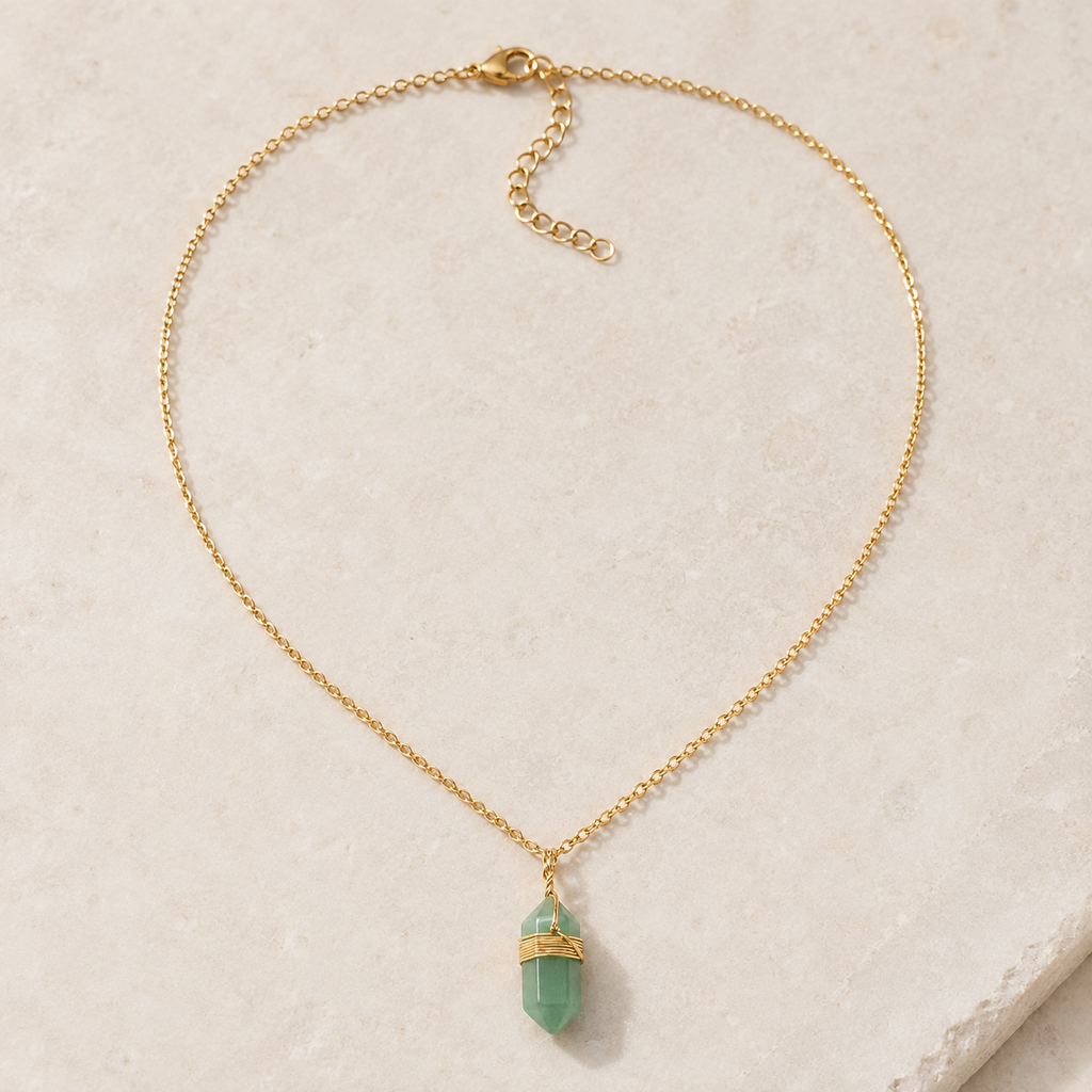 Collier doré en aventurine verte présenté en entier sur une surface minérale claire