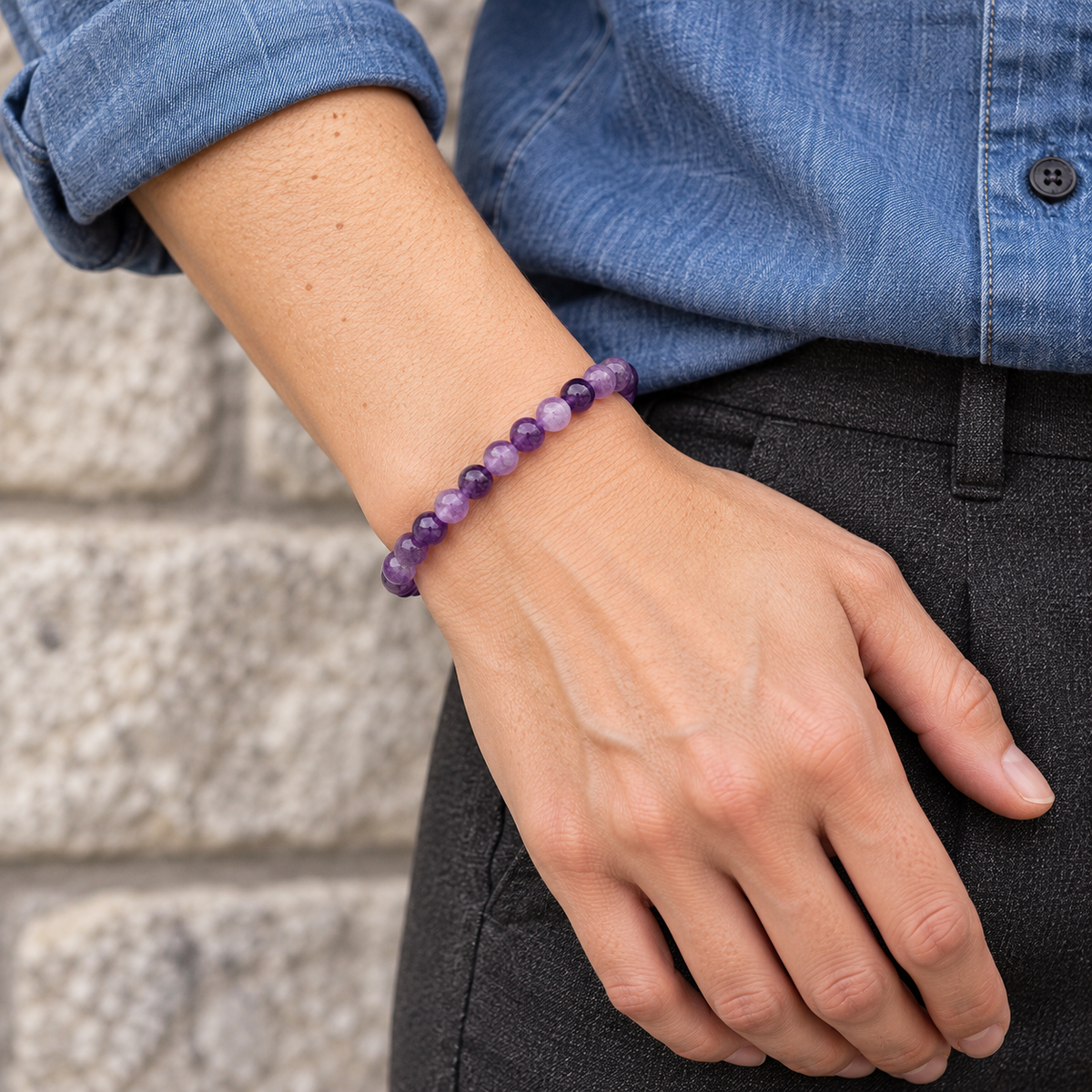 Bracelet en améthyste 6 mm porté au poignet, avec une chemise en denim.
