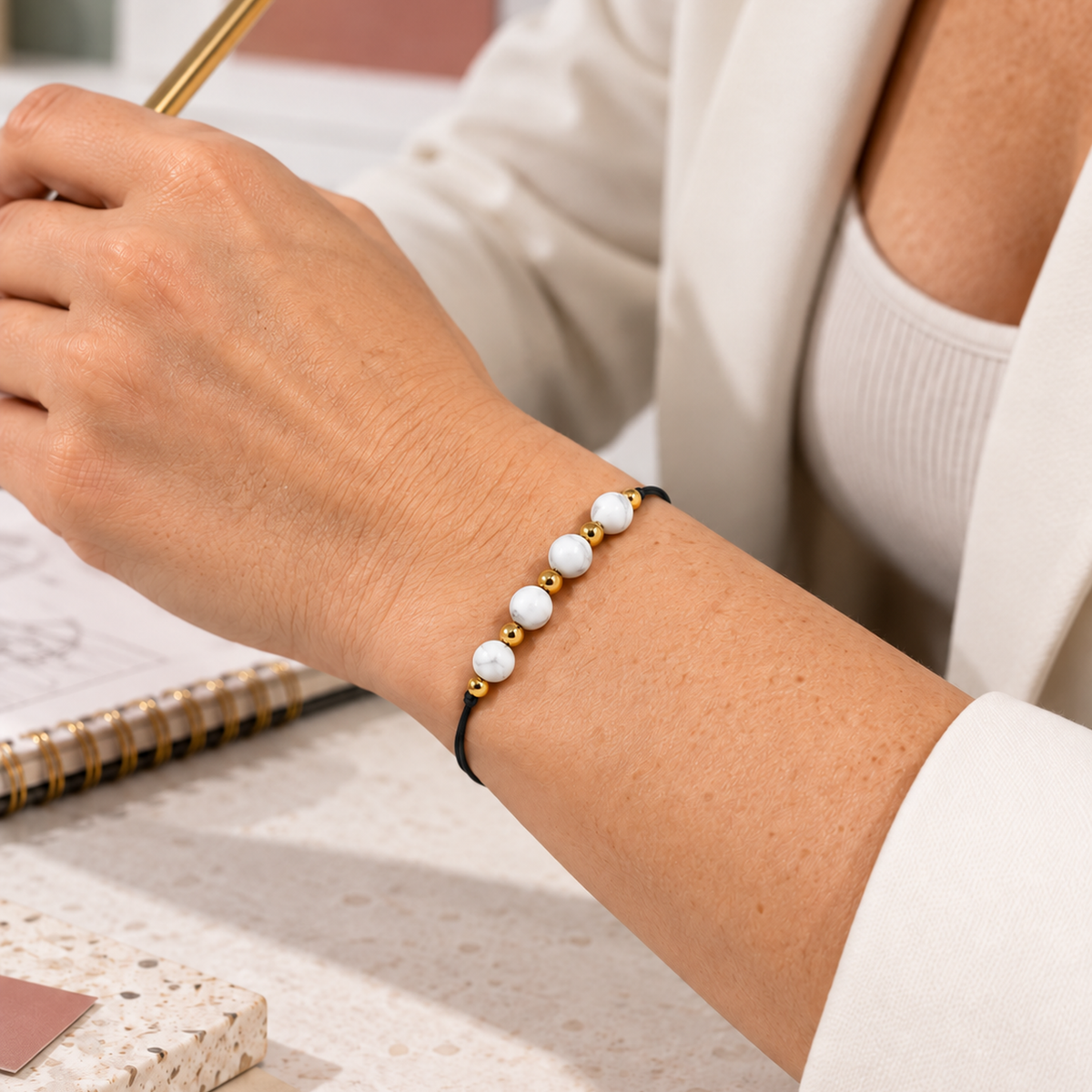 Bracelet doré en howlite blanche 6 mm porté au poignet à son échelle réelle dans une lumière naturelle