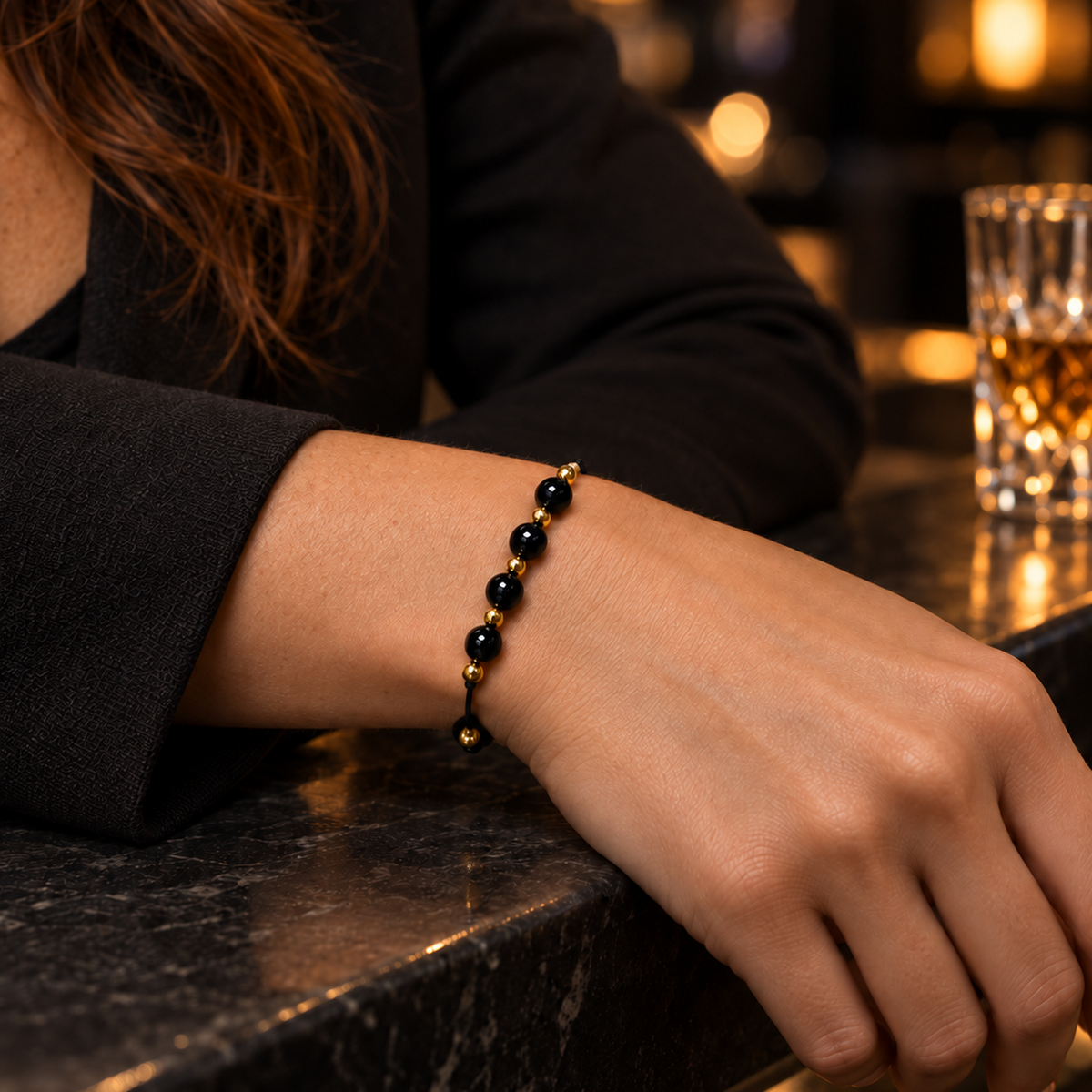 Bracelet doré en obsidienne noire 6 mm porté au poignet à son échelle réelle dans une lumière naturelle