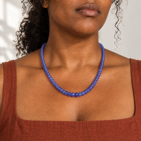 Collier en tanzanite de 45 cm porté près des clavicules, avec un rang de perles graduées.