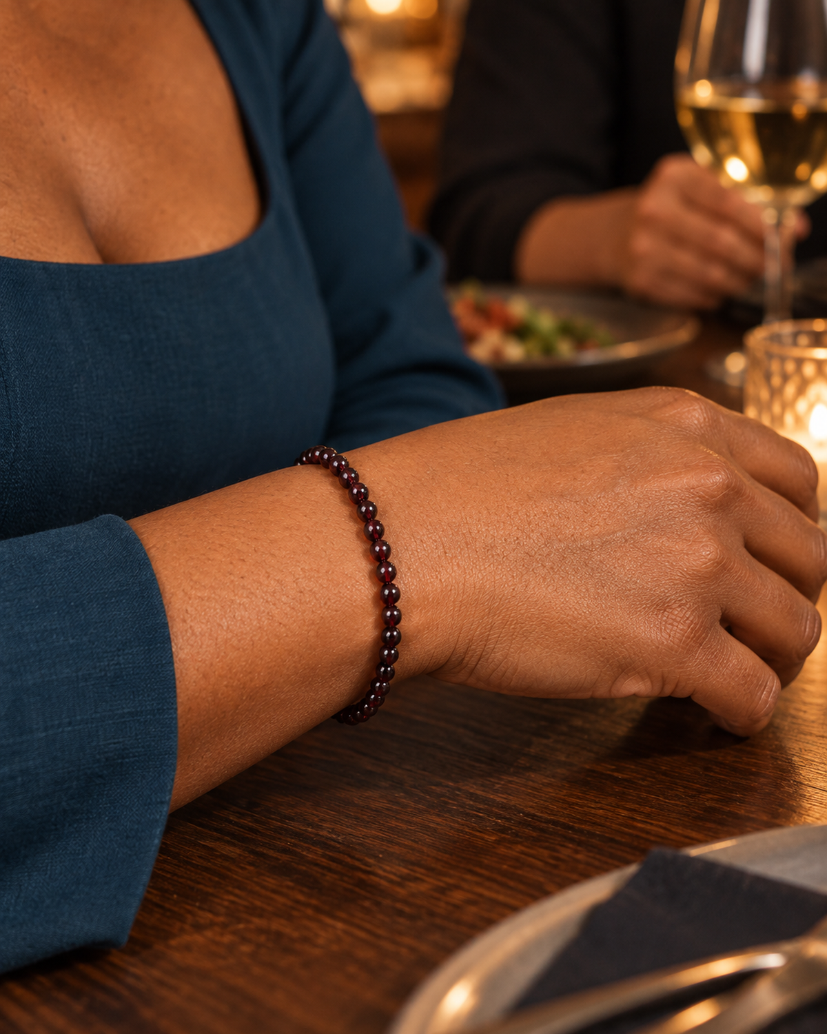 Bracelet en grenat rouge 4 mm porté au poignet à l'échelle annoncée