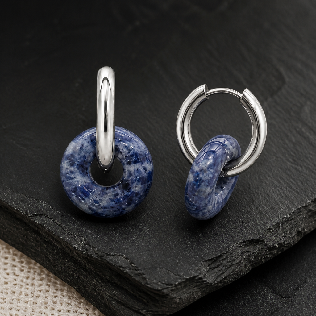 Boucles d'oreilles Loa argentées en sodalite 25 mm, présentation sur une surface sombre contrastée