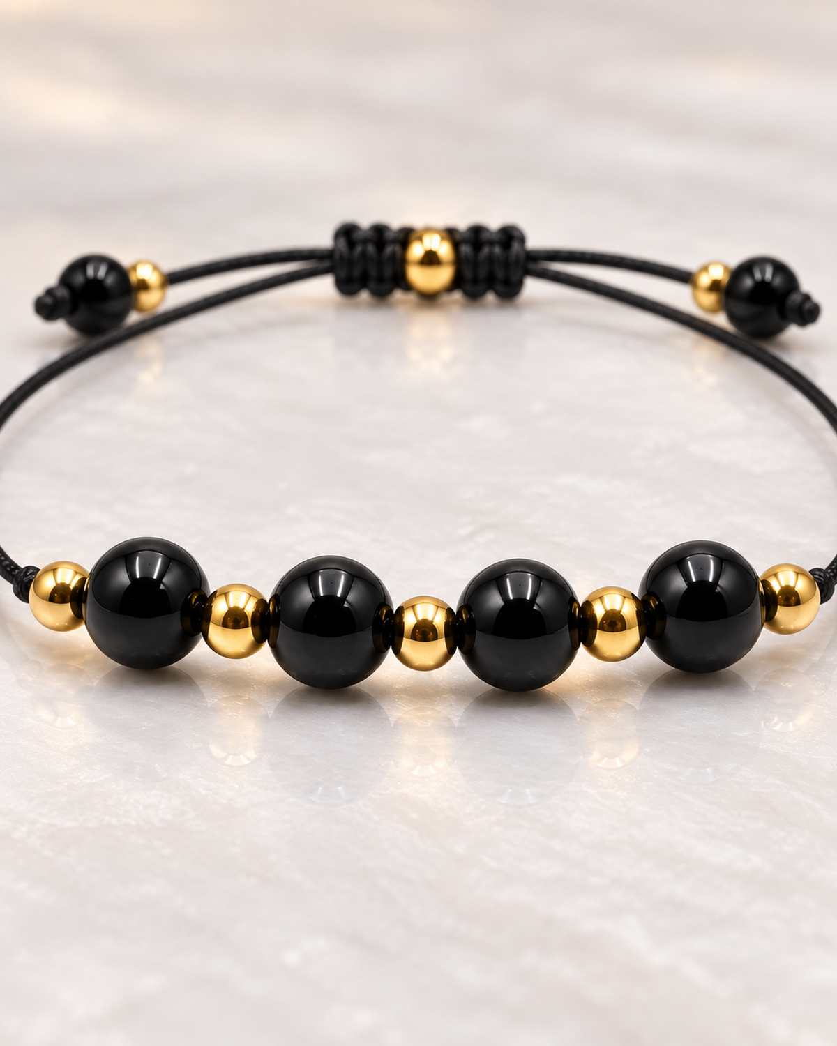Macro des pierres et de la construction centrale du bracelet doré en obsidienne noire 6 mm