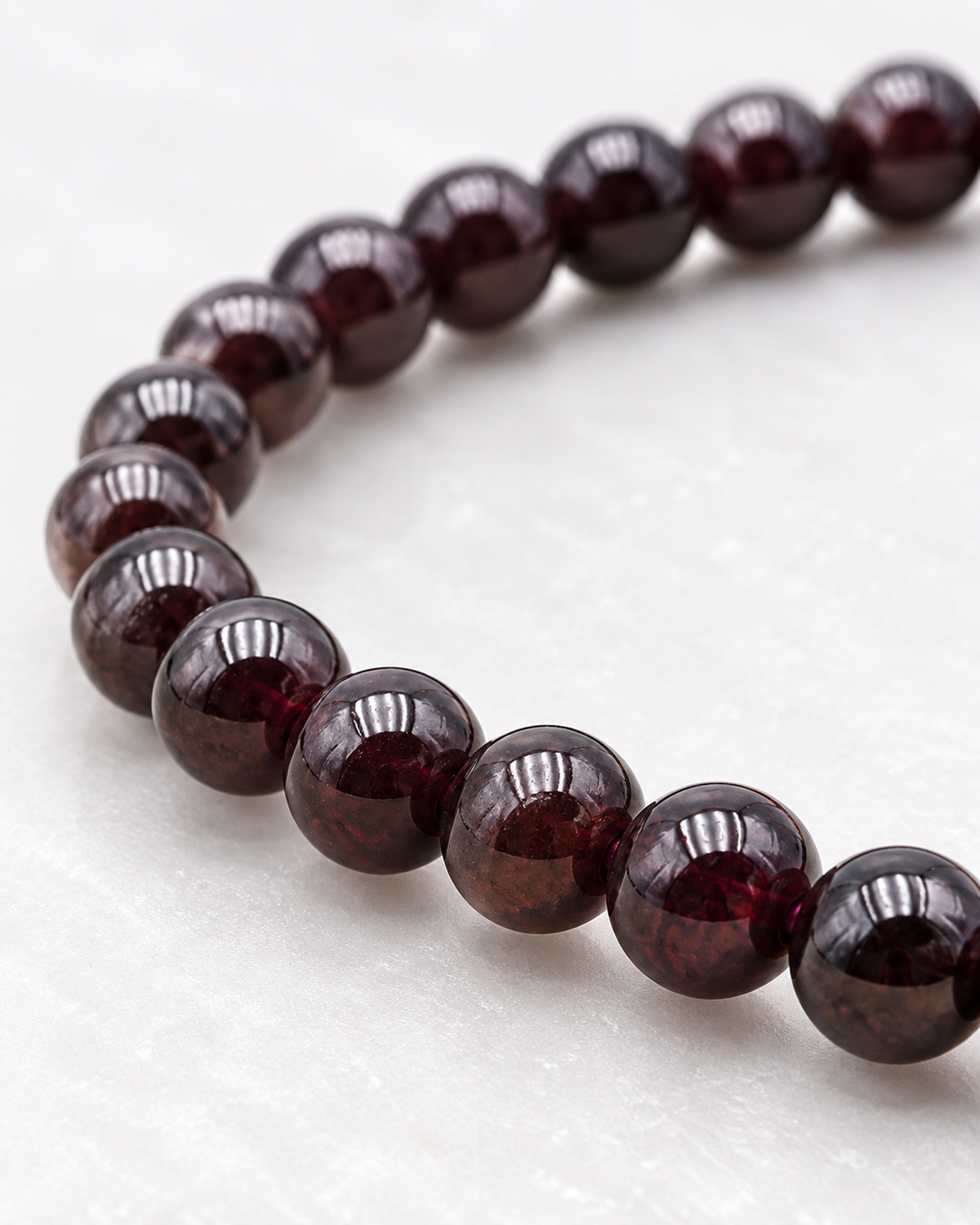 Macro des perles de grenat et de leur finition sur Bracelet en grenat rouge 6 mm