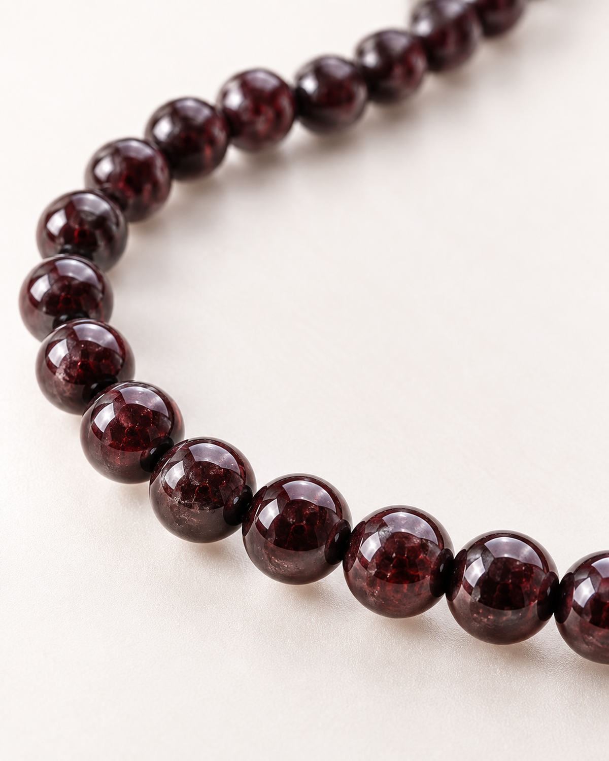 Macro des perles de grenat et de leur finition sur Collier en grenat rouge 6 mm - 45 cm