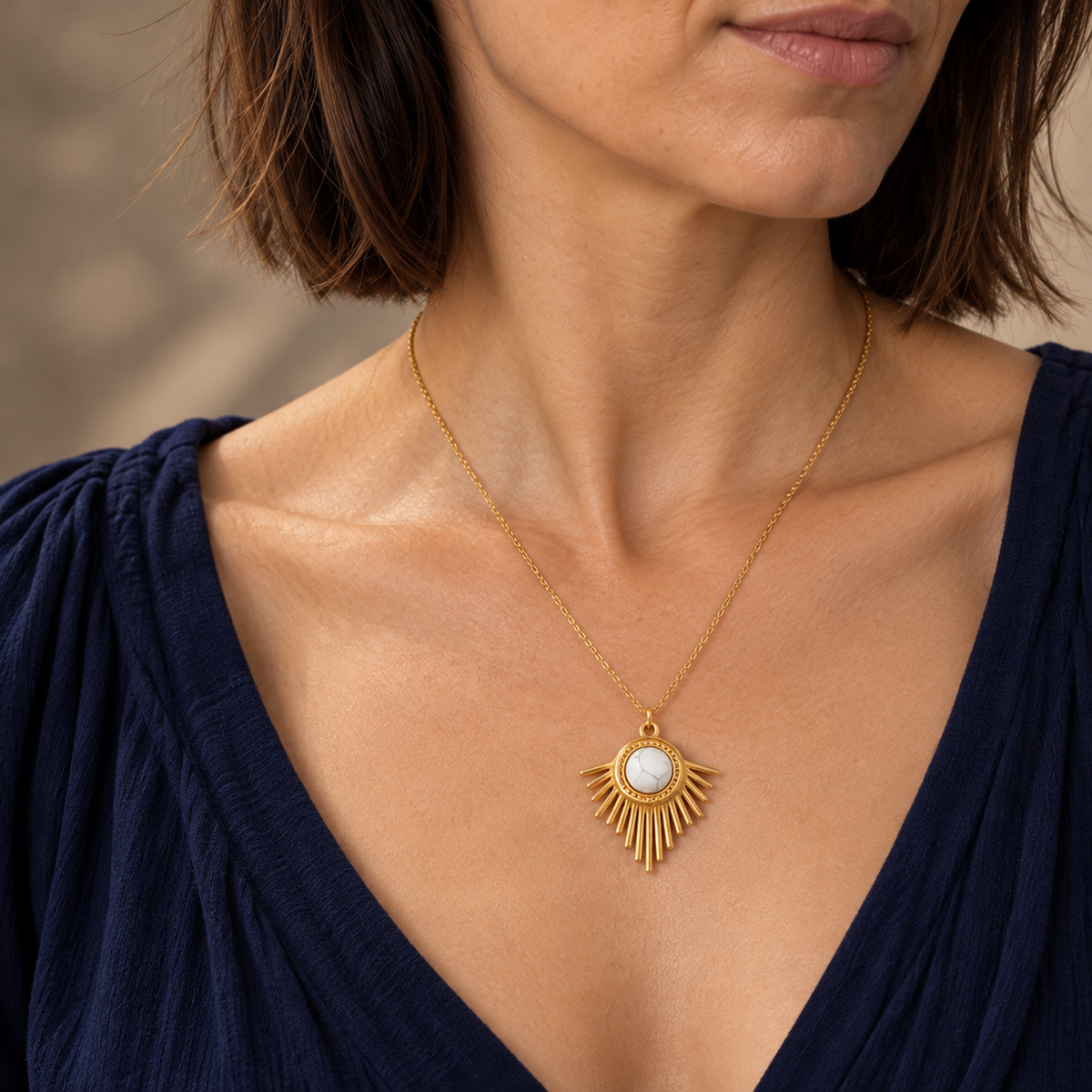 Collier doré en howlite blanche à pendentif rayonnant : porté de trois quarts