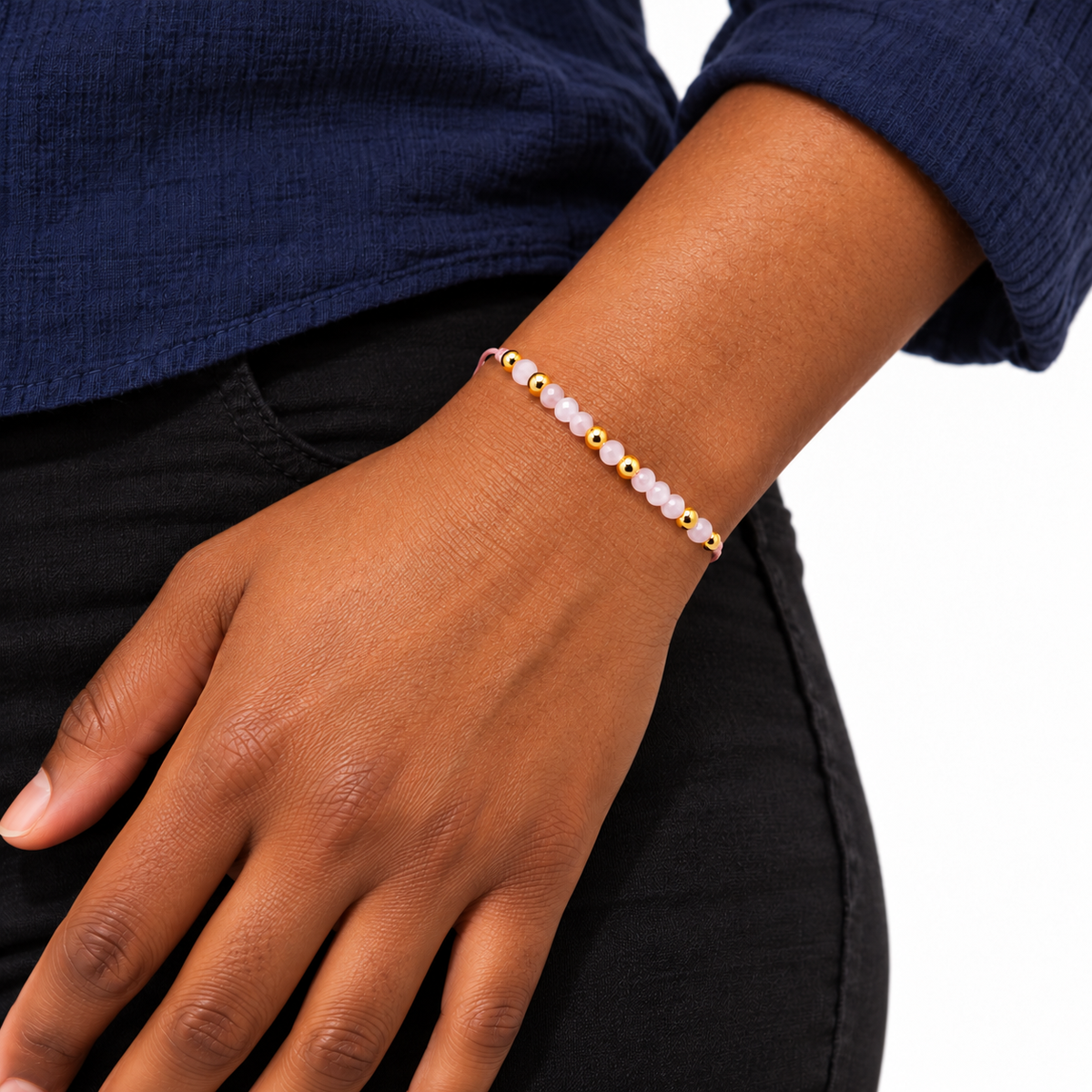 Bracelet quartz rose et perles dorées porté avec une tenue unie