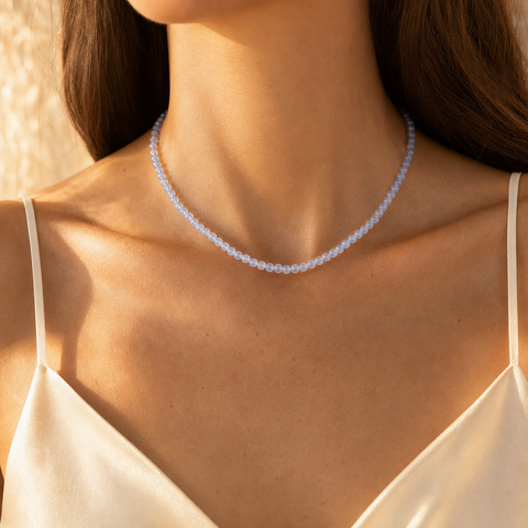 Collier calcédoine bleue porté au cou sur haut en lin crème