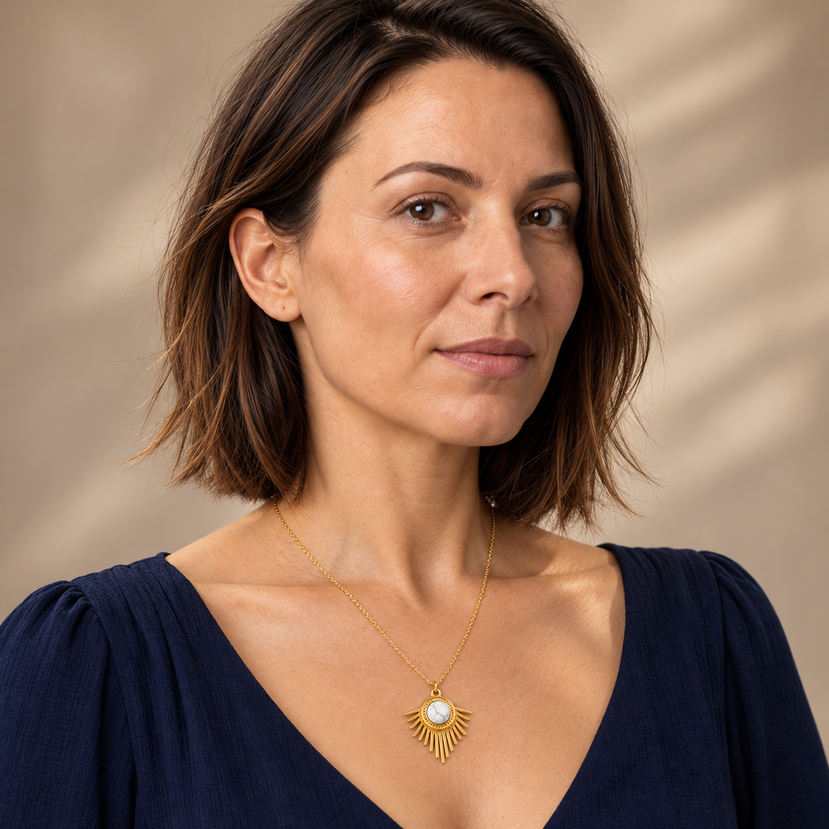 Collier doré en howlite blanche à pendentif rayonnant : portrait au collier lisible