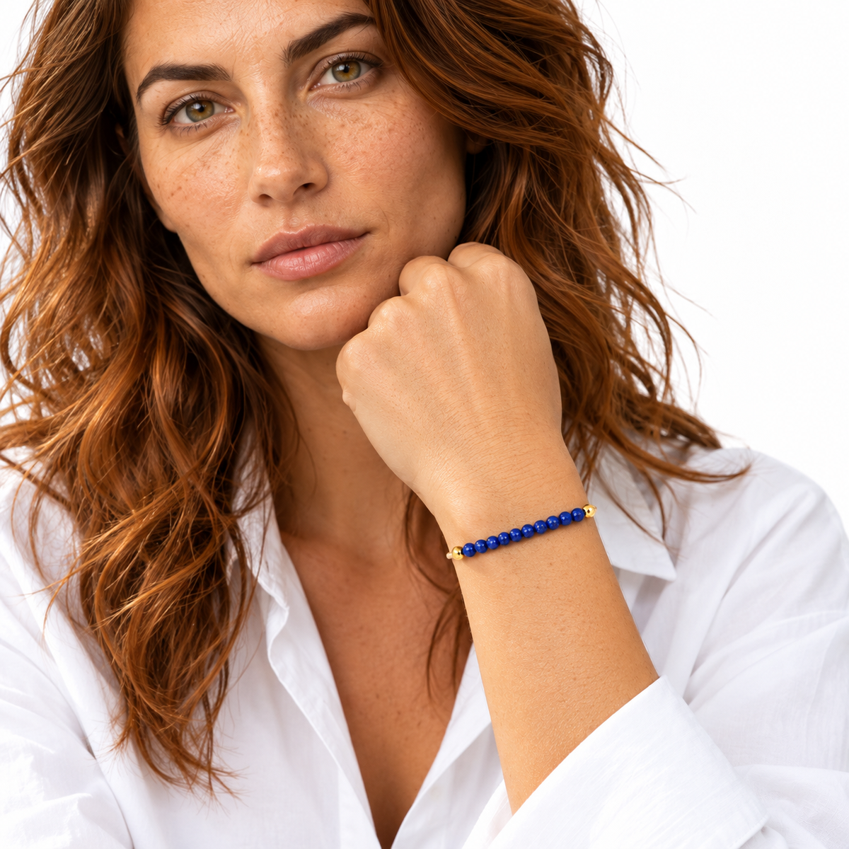 Bracelet lapis-lazuli porté par Chloé, poignet au premier plan et chemise blanche