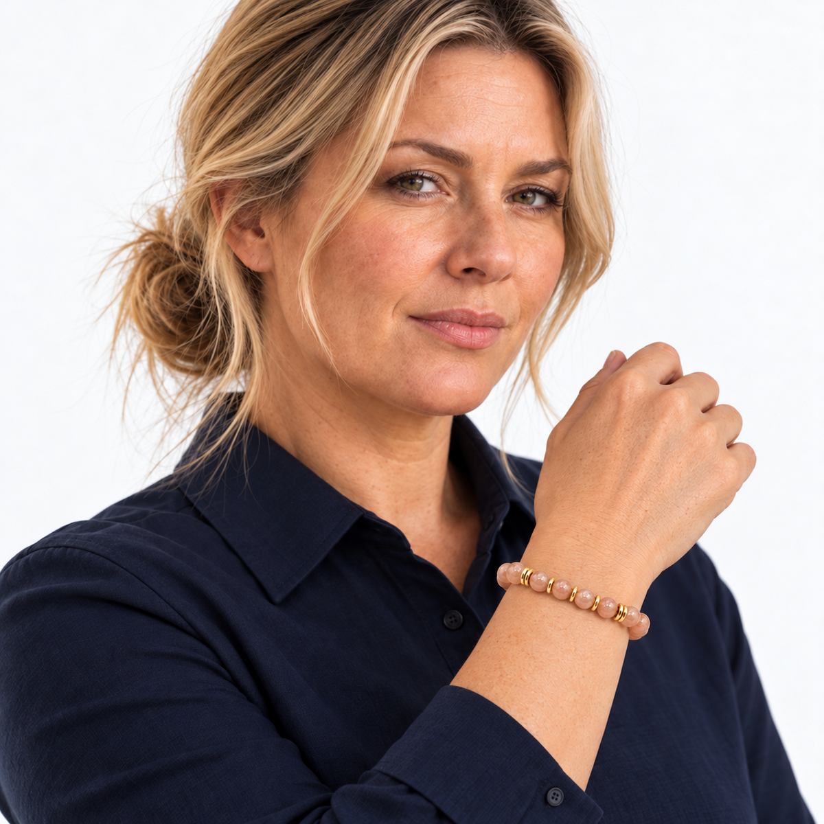 Bracelet en pierre de lune rose porté avec une chemise bleu marine, poignet relevé