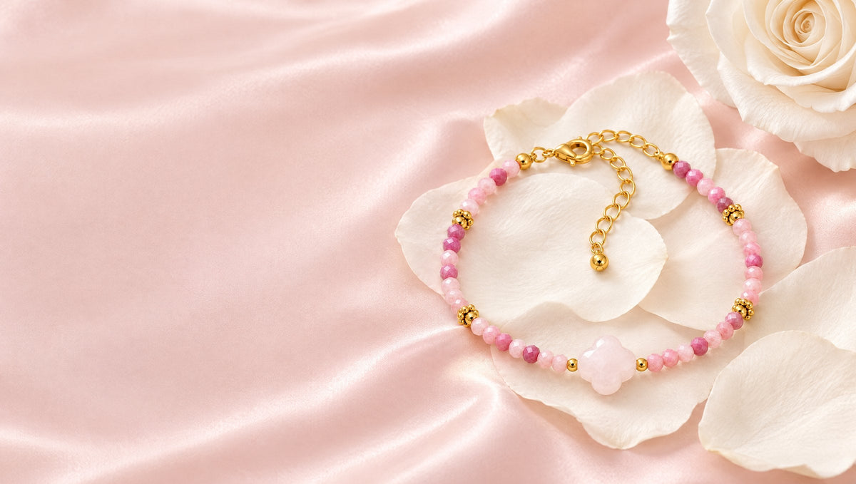 Bracelet Rosalia doré en quartz rose et rhodonite posé sur des pétales de rose ivoire
