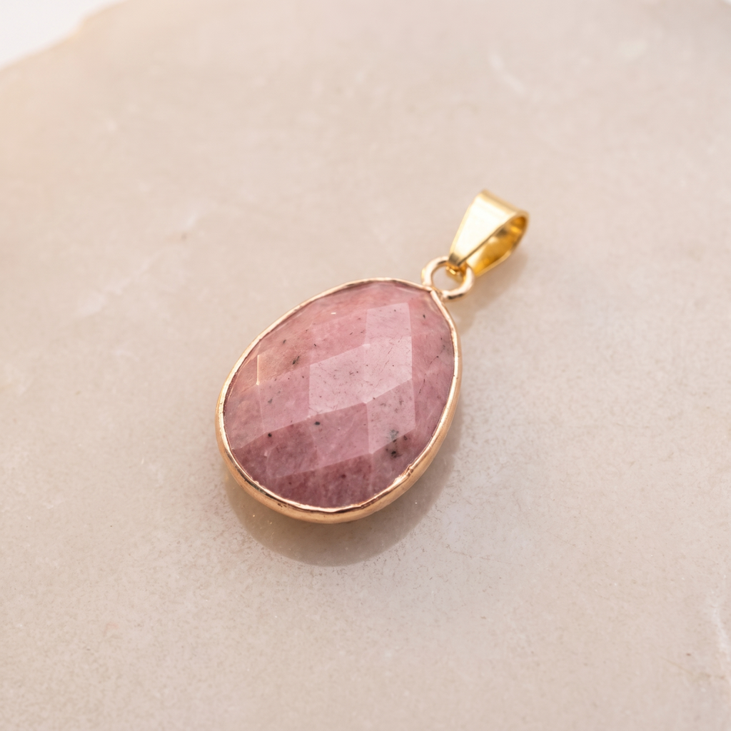 Pendentif ovale en rhodonite rose facettée avec serti et bélière dorés