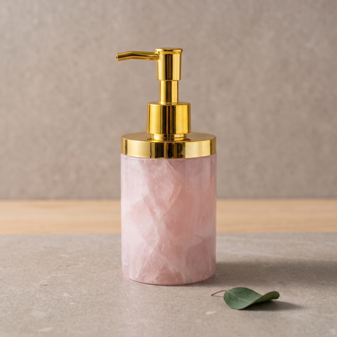 Distributeur de savon cylindrique en quartz rose pâle avec pompe dorée sur fond clair