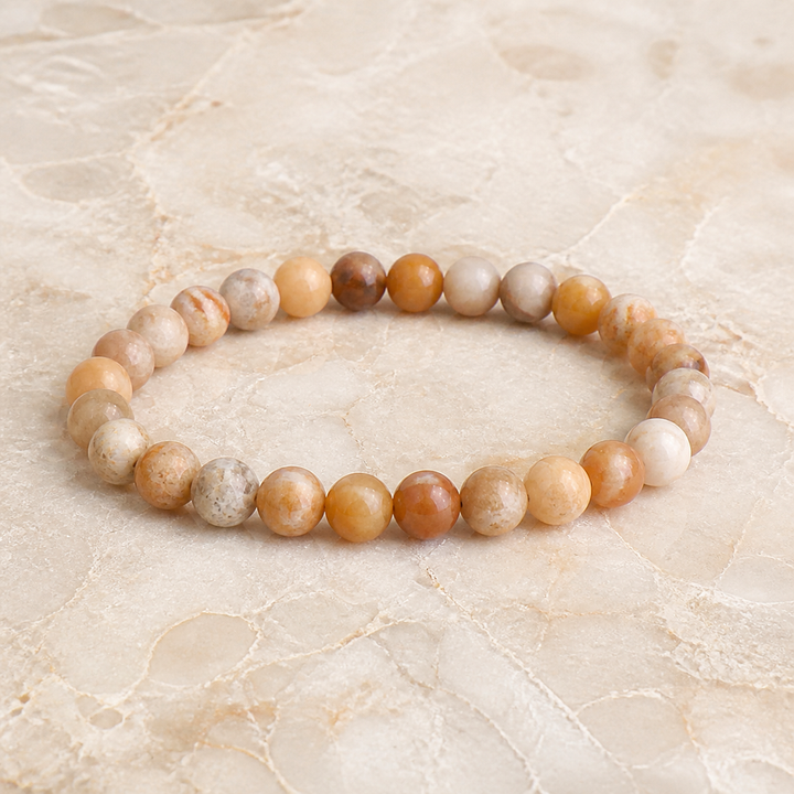 Bracelet en corail fossile 6 mm - 16 à 18 cm, vue complète sur une surface minérale claire