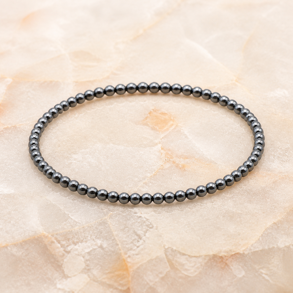 Bracelet fin en hématite - Perles de 4 mm, vue complète sur une surface minérale claire