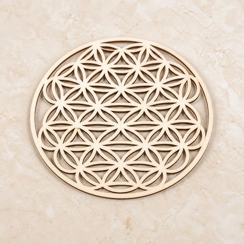 Plaque Fleur de Vie ajourée en bois - 10 cm, vue complète sur une surface minérale claire