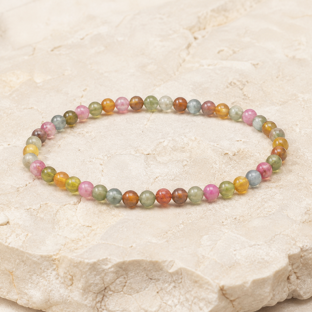 Bracelet en tourmaline multicolore 4 mm - 16 à 18 cm, vue complète sur une surface minérale claire