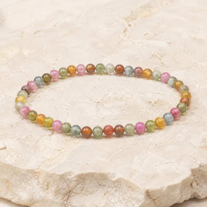 Bracelet en tourmaline multicolore 4 mm - 16 à 18 cm, vue complète sur une surface minérale claire