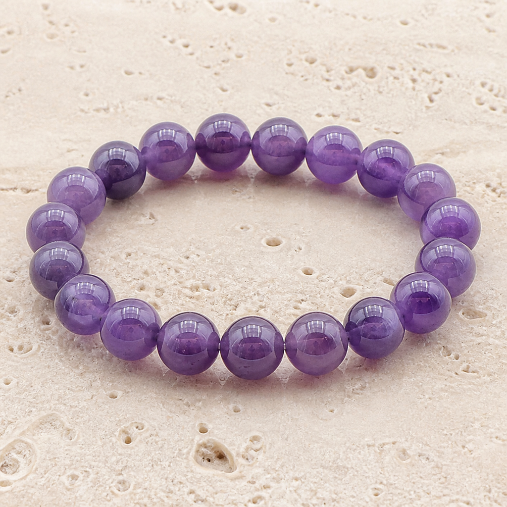 Bracelet en améthyste du Brésil 10 mm sur travertin clair