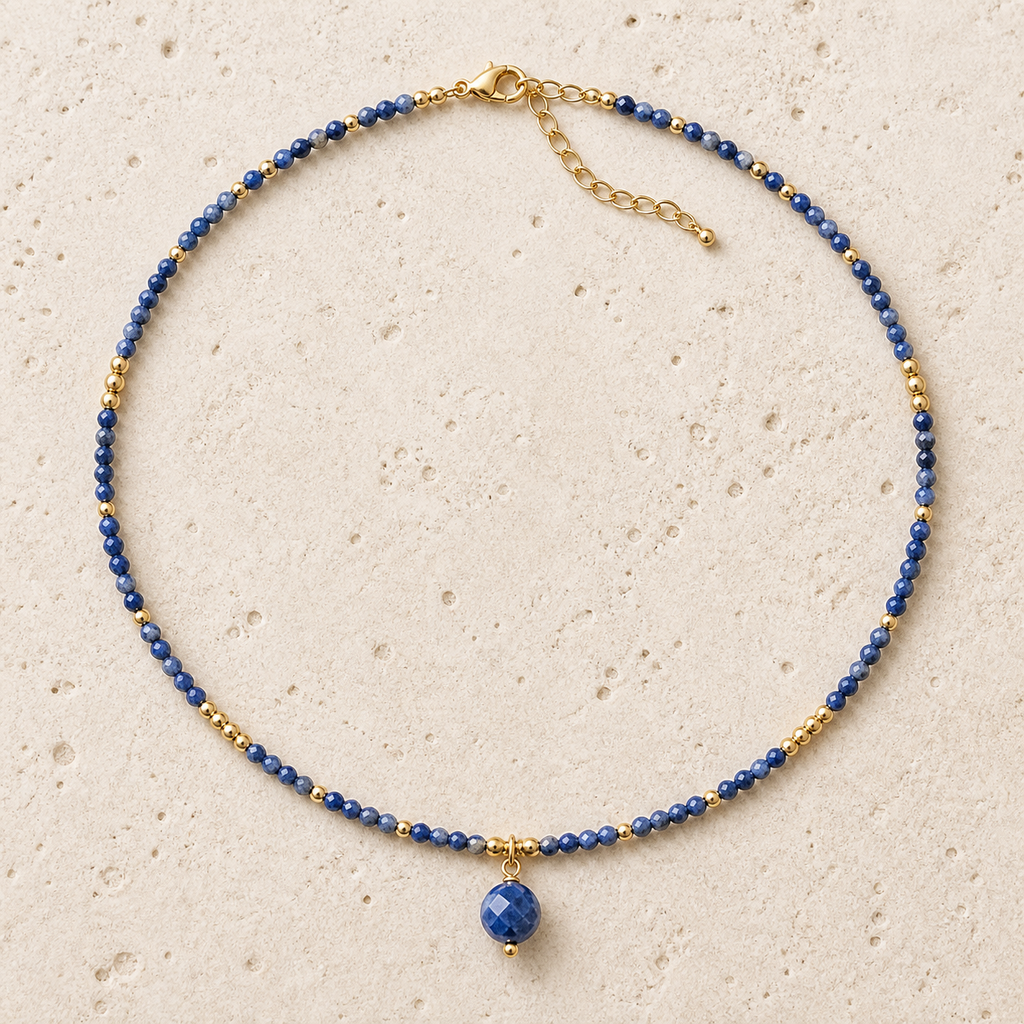 Collier doré en sodalite facettée - 38 à 43 cm, vue complète sur une surface minérale claire