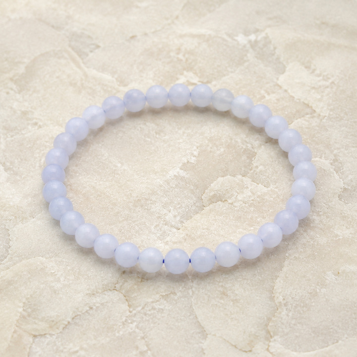 Bracelet en calcédoine bleue de Namibie - Perles de 6 mm, vue complète sur une surface minérale claire