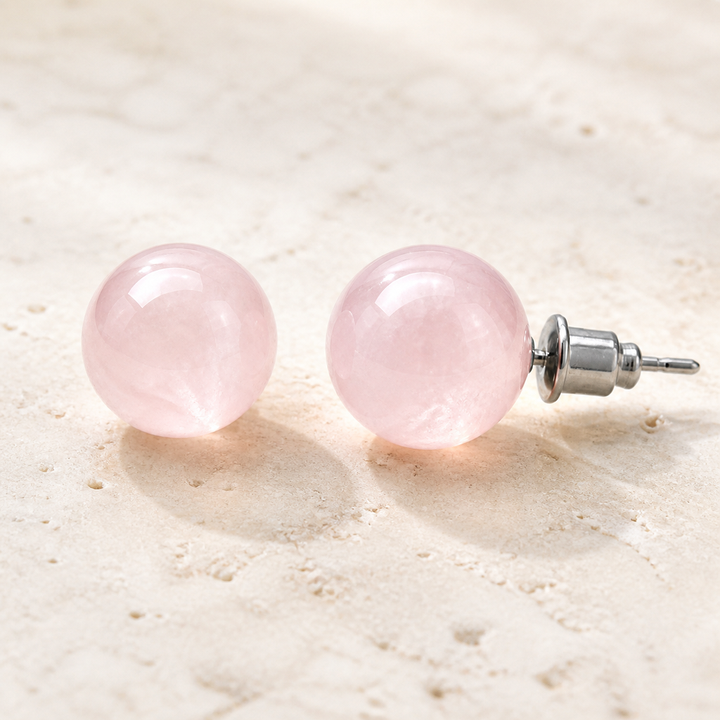 Boucles d'oreilles puces en quartz rose 10 mm, vue complète sur une surface minérale claire