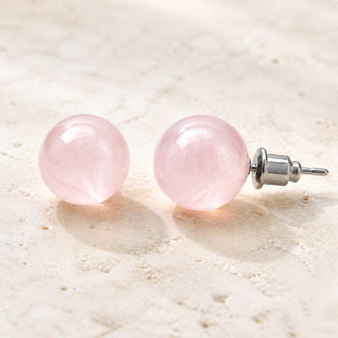 Boucles d'oreilles puces en quartz rose 10 mm, vue complète sur une surface minérale claire