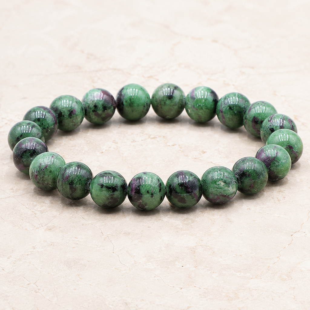 Bracelet en zoïsite - Perles de 10 mm présenté en entier sur une surface minérale claire