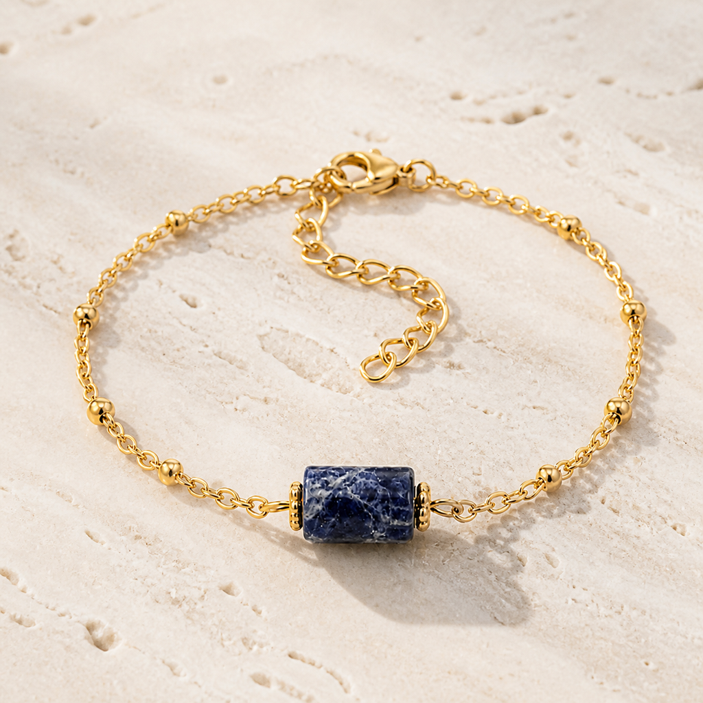 Bracelet Cléa doré en sodalite 8 mm, vue complète sur une surface minérale claire
