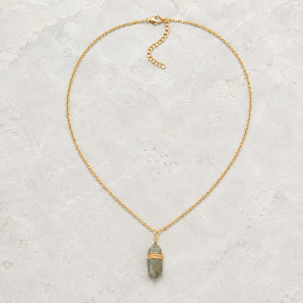 Collier doré en labradorite présenté en entier sur une surface minérale claire