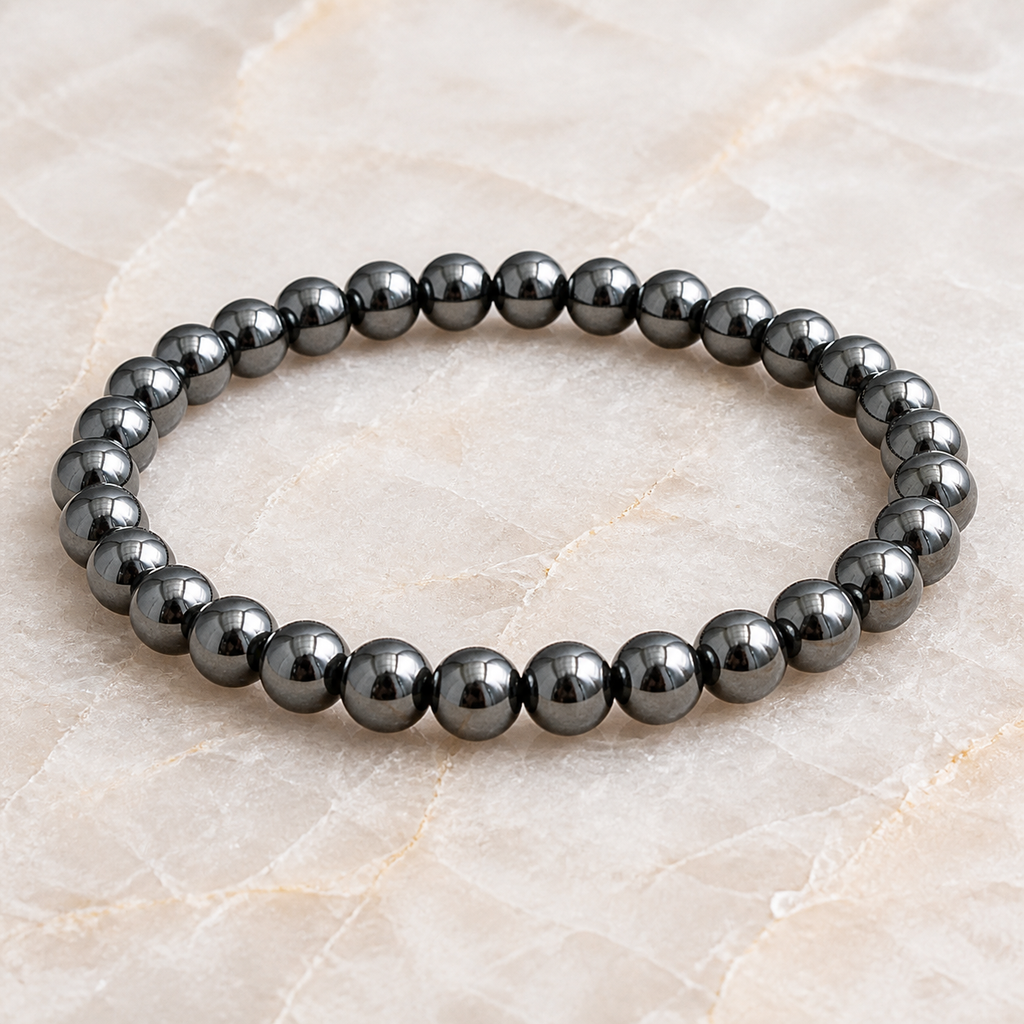 Bracelet en hématite - Perles de 6 mm, vue complète sur une surface minérale claire
