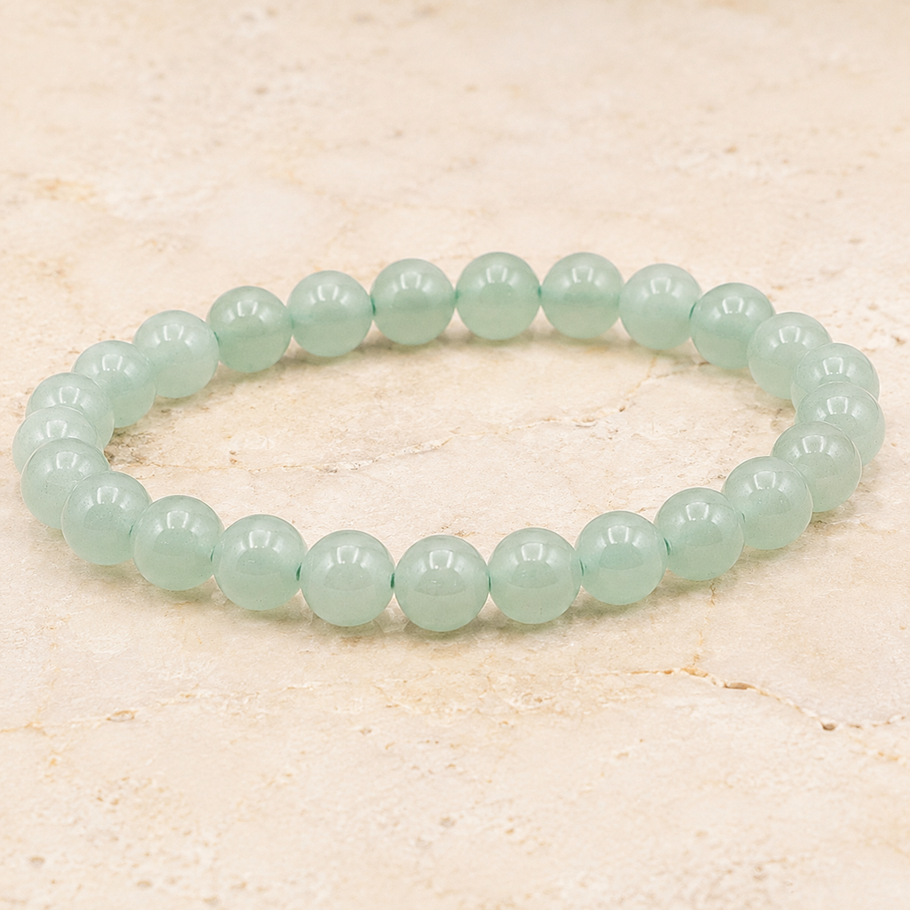 Bracelet en aventurine verte - Perles de 8 mm présenté en entier sur une surface minérale claire