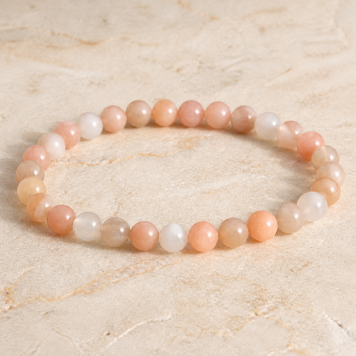 Bracelet en pierre de lune multicolore - Perles de 6 mm, vue complète sur une surface minérale claire