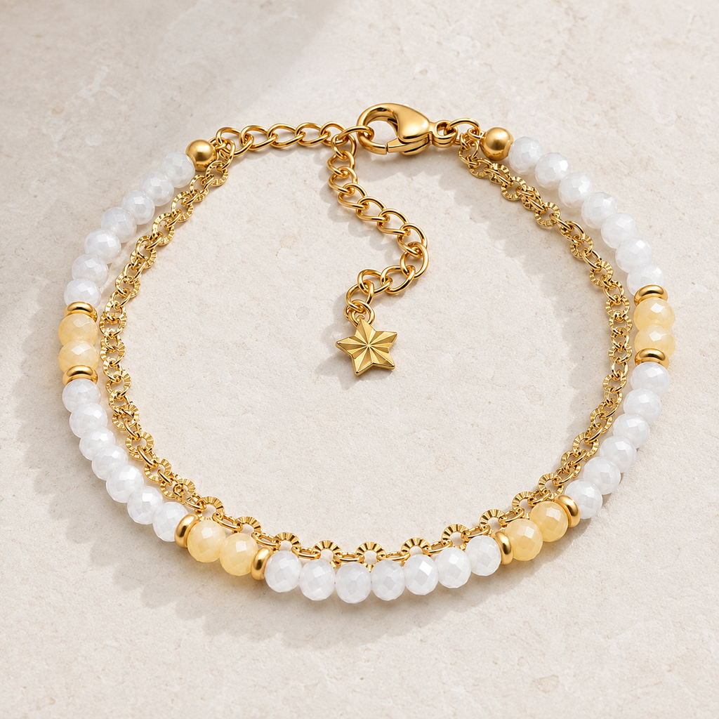 Bracelet doré en nacre et pierre de lune présenté en entier sur une surface minérale claire