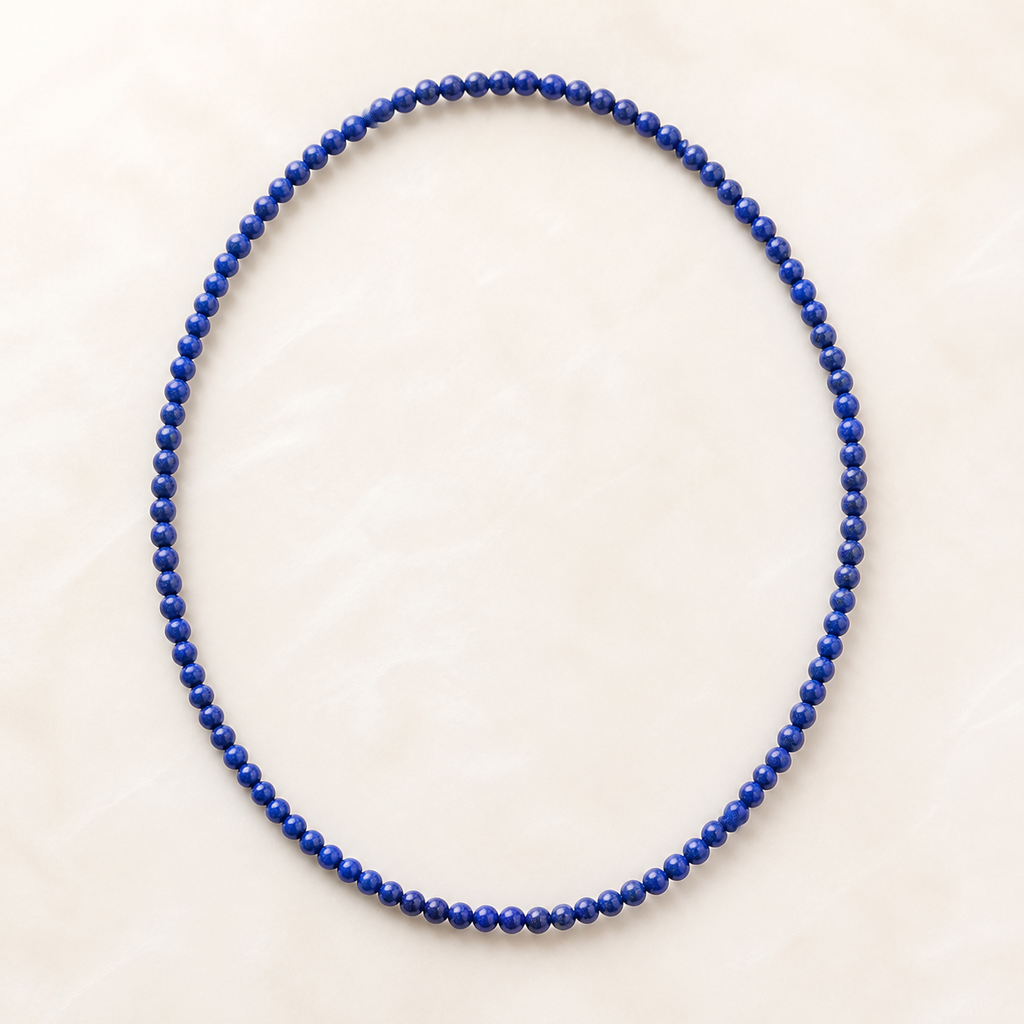 Collier en lapis-lazuli d'Afghanistan 4 mm - 45 cm, vue complète sur une surface minérale claire