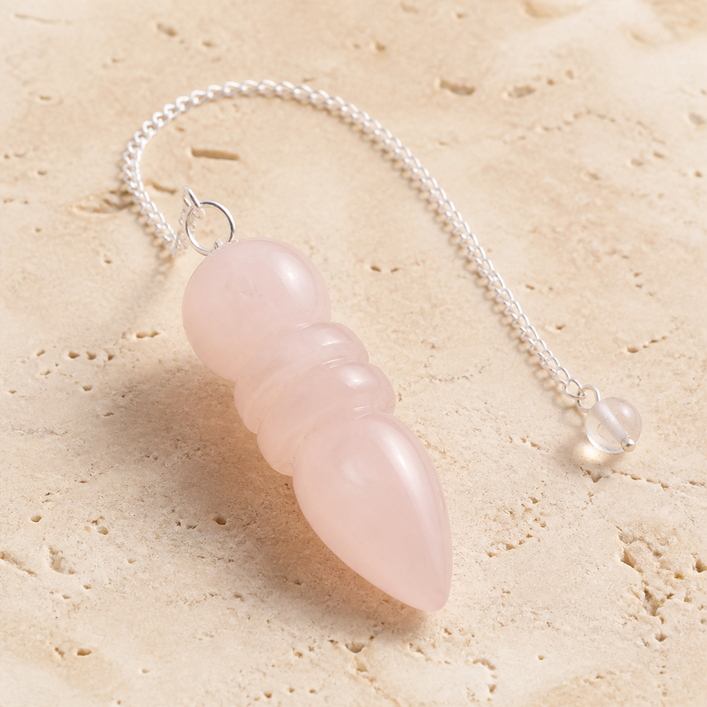 Pendule égyptien en quartz rose du Brésil, vue complète sur une surface minérale claire