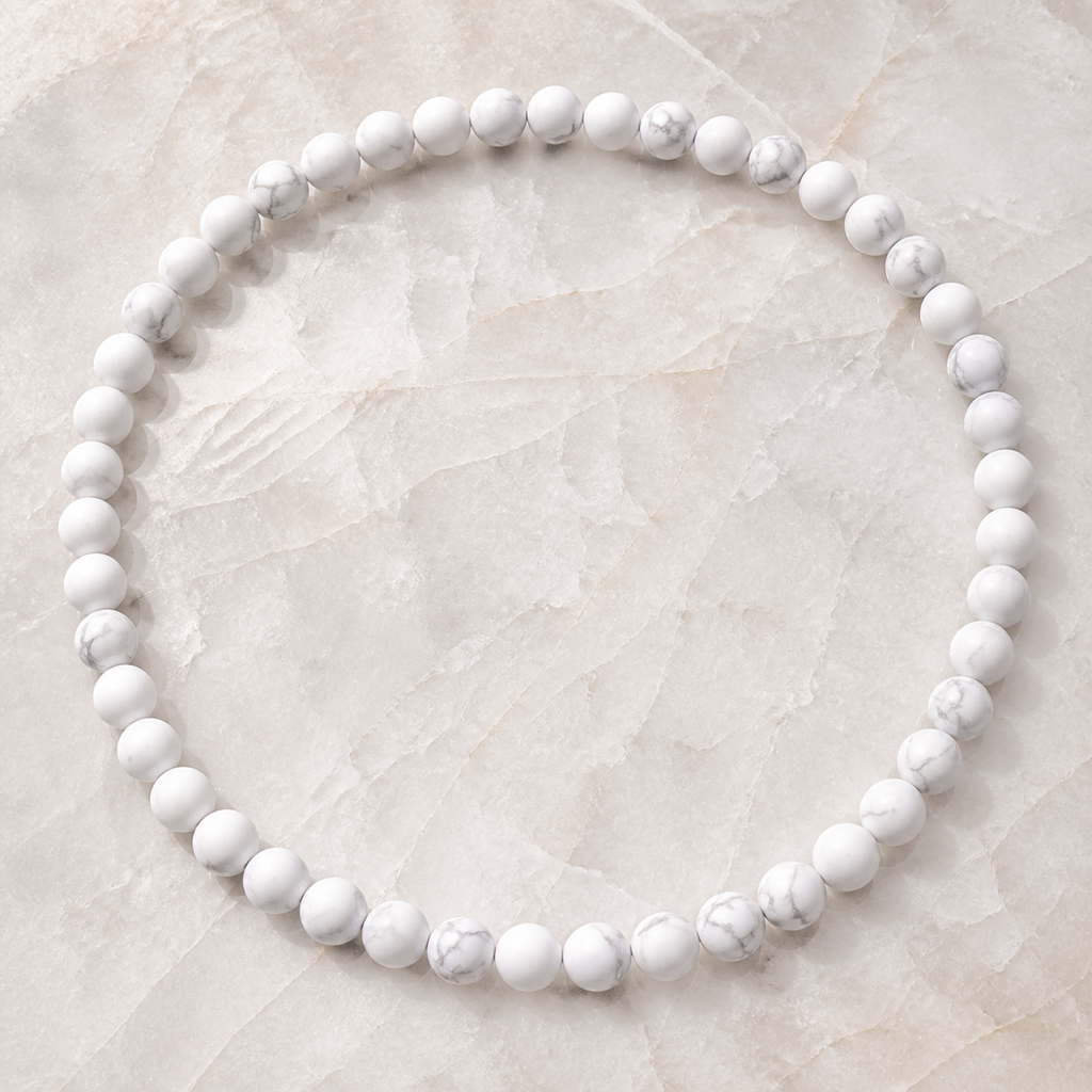 Collier en howlite blanche 8 mm - 45 cm, vue complète sur une surface minérale claire