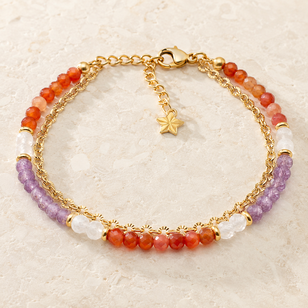 Bracelet doré en améthyste, cornaline et cristal de roche présenté en entier sur une surface minérale claire