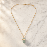 Collier doré boho en aventurine verte naturelle sur marbre clair