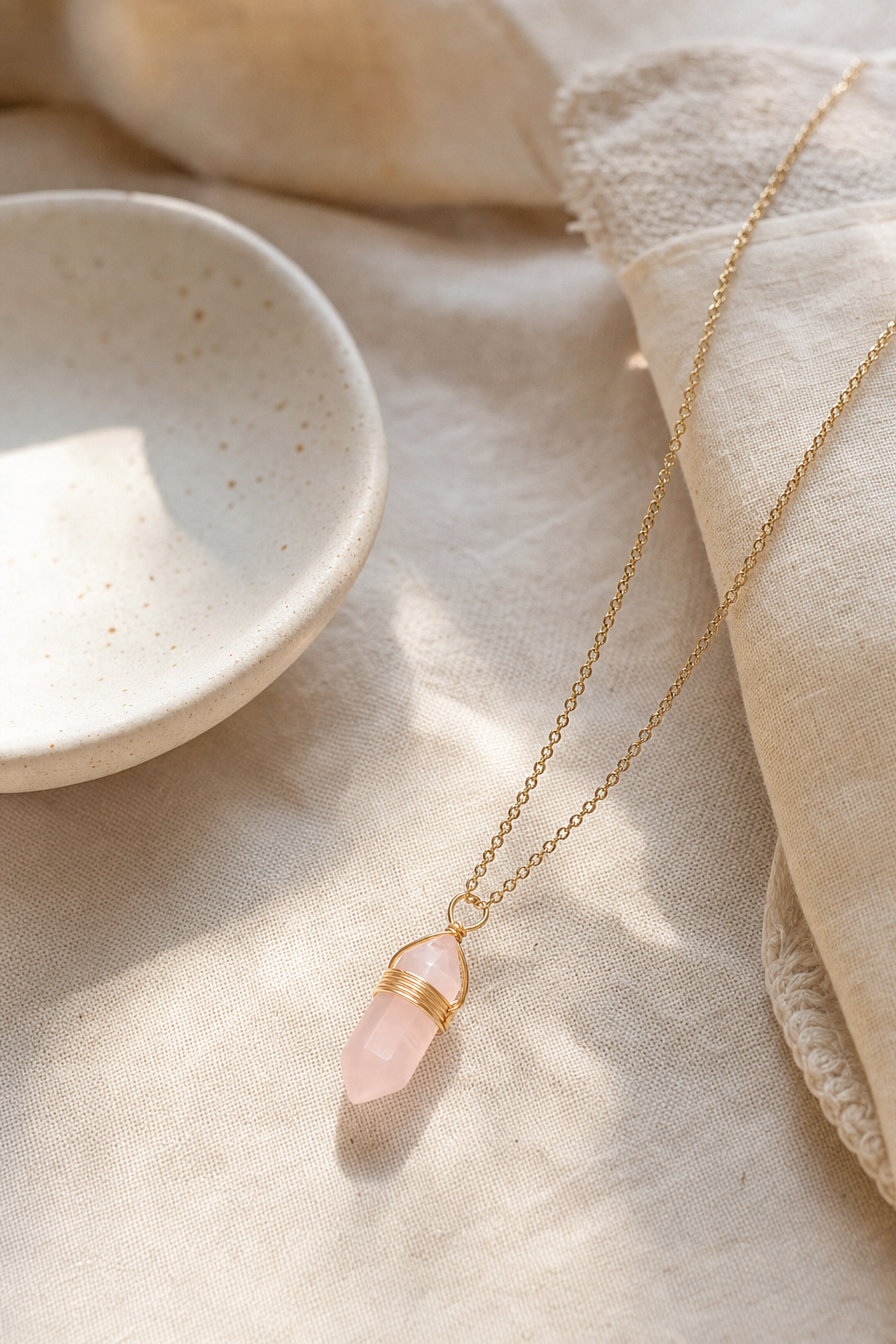 Collier quartz rose doré présenté dans une ambiance douce et naturelle