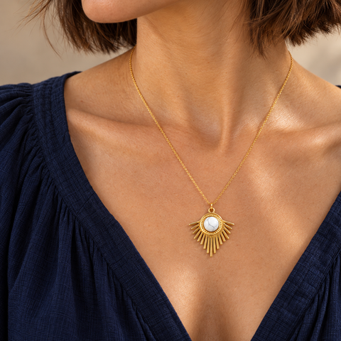Collier doré en howlite blanche à pendentif rayonnant : échelle au décolleté