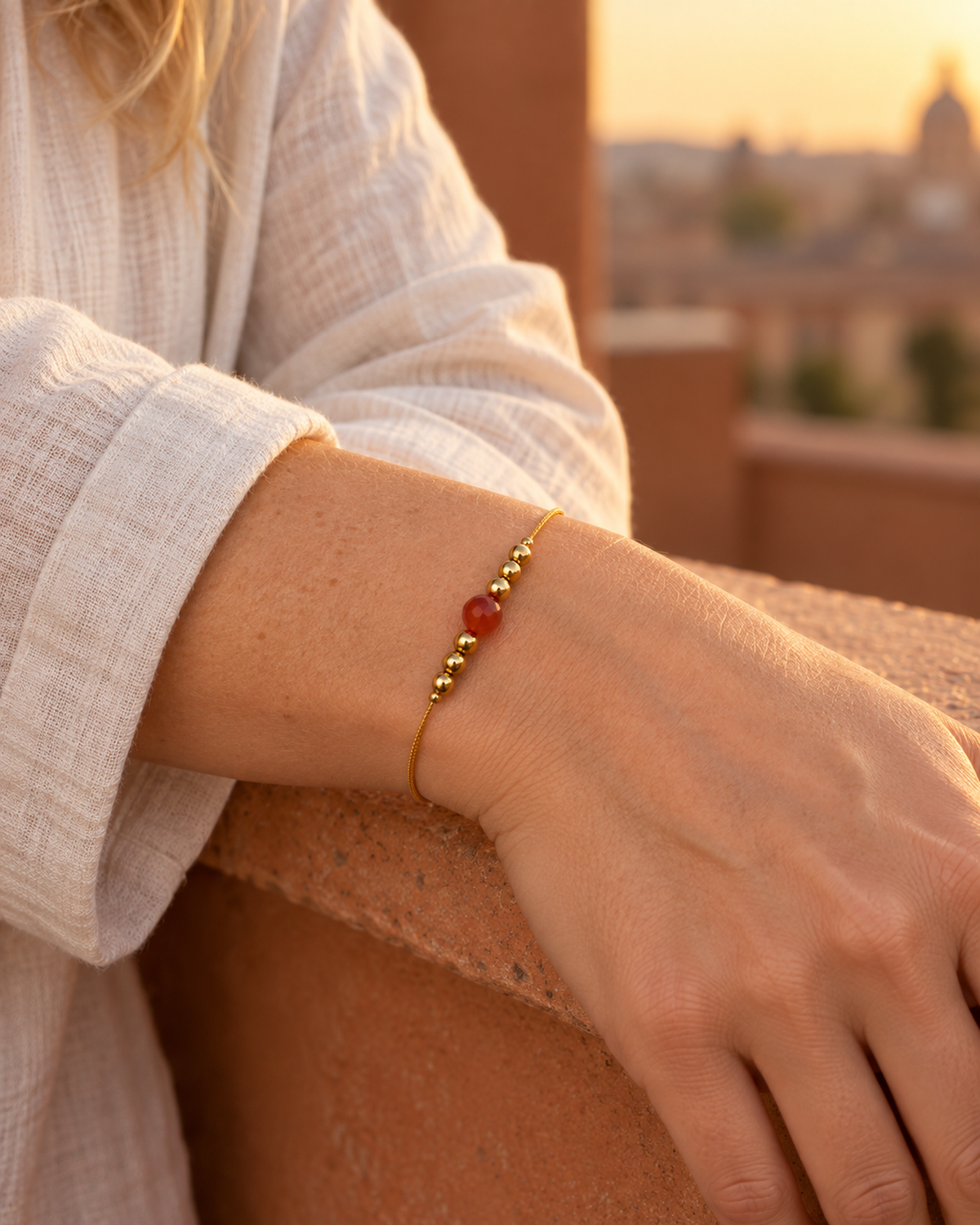 Bracelet doré en cornaline 6 mm porté au poignet à son échelle réelle dans une lumière naturelle