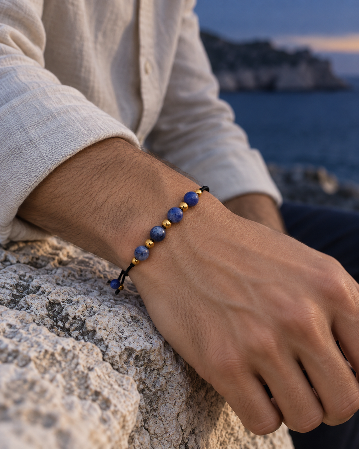 Bracelet doré en sodalite 6 mm porté au poignet à son échelle réelle dans une lumière naturelle
