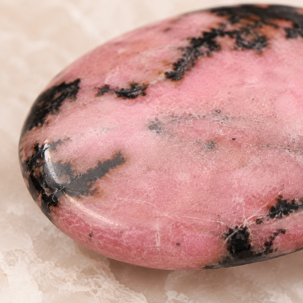 Gros plan de la surface polie et des veines du galet en rhodonite