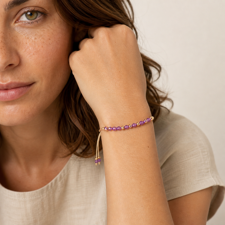 Bracelet Murmure doré en améthyste 4 mm porté par Chloé en gros plan