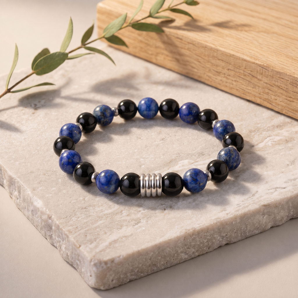 Bracelet bleu noir et argenté sur pierre claire avec une branche verte discrète