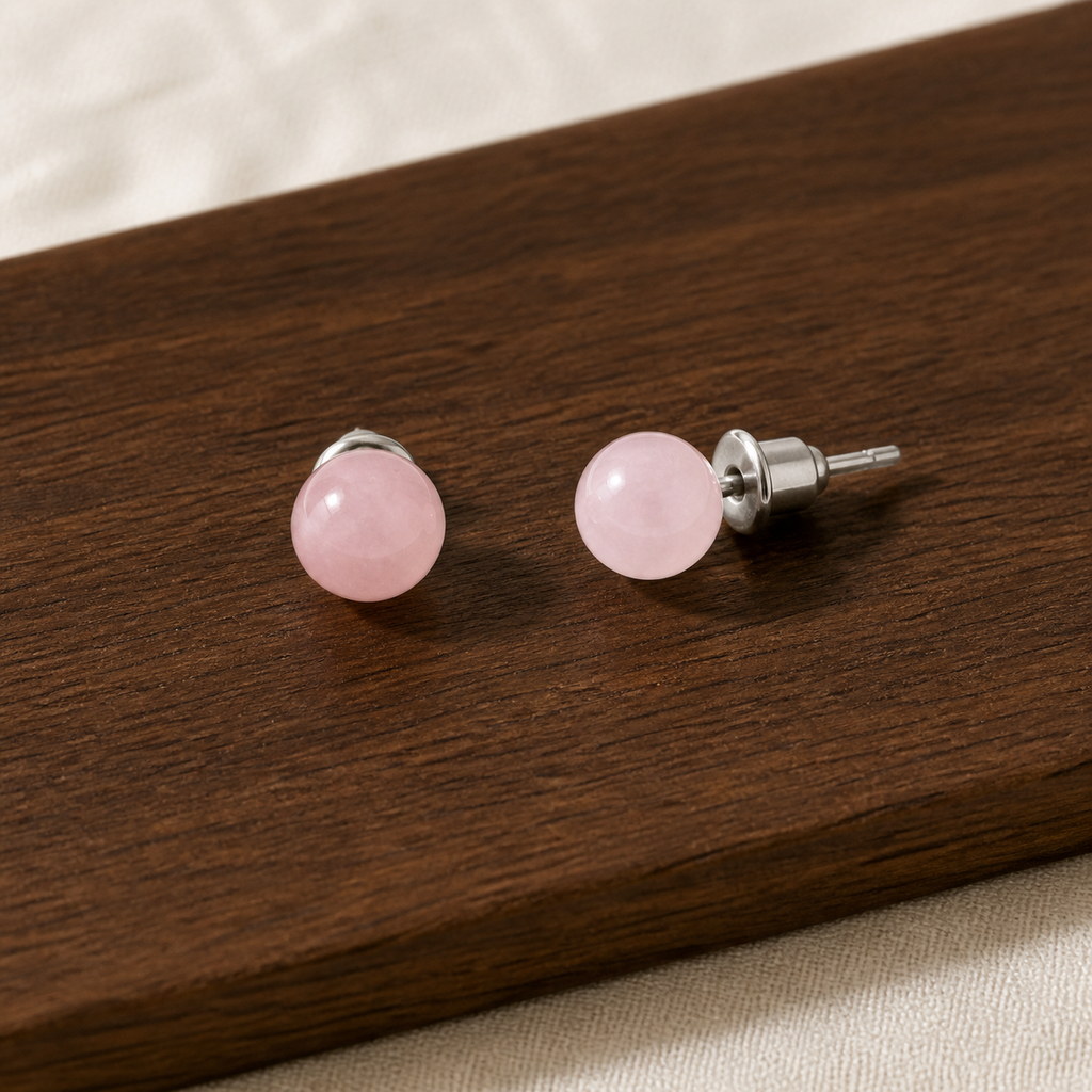 Boucles d'oreilles puces en quartz rose 6 mm, présentation sur une surface sombre contrastée